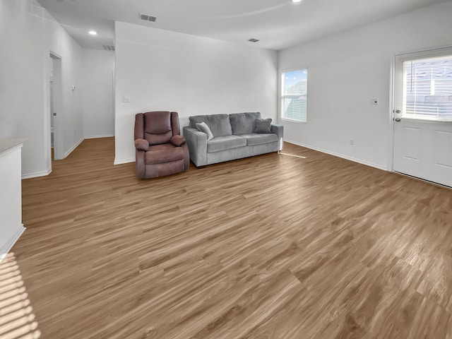 living area with light wood-style floors, baseboards, and recessed lighting