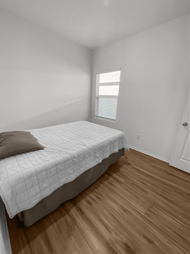 bedroom featuring wood finished floors and baseboards