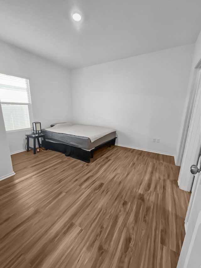 bedroom featuring baseboards and wood finished floors