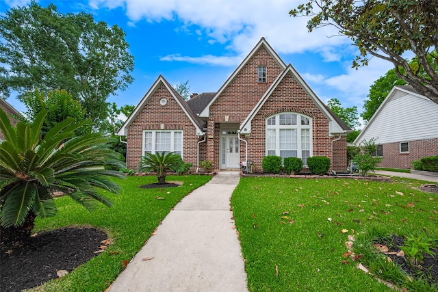 view of front facade featuring brick siding and a front yard