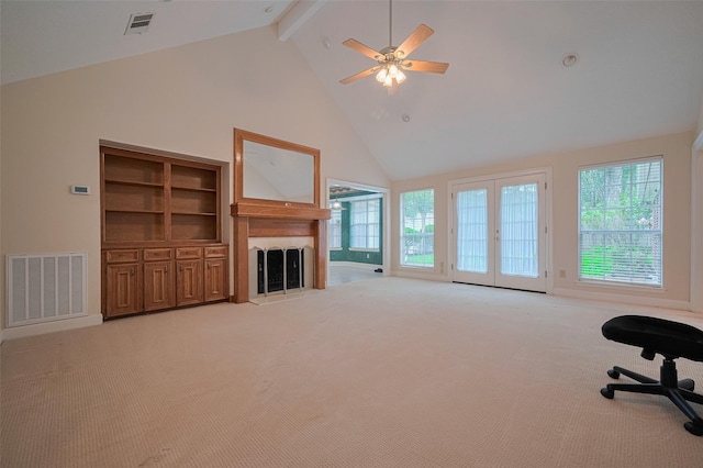 unfurnished living room with plenty of natural light, high vaulted ceiling, a fireplace with raised hearth, light carpet, and beam ceiling