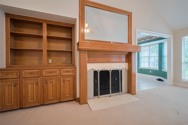 unfurnished living room with light colored carpet, a fireplace, lofted ceiling, and baseboards