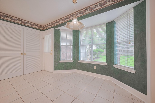 spare room with light tile patterned flooring and baseboards