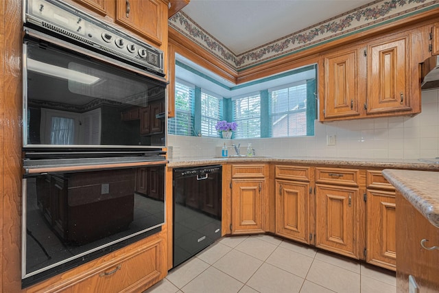 kitchen featuring black appliances, a sink, brown cabinets, tasteful backsplash, and light tile patterned floors