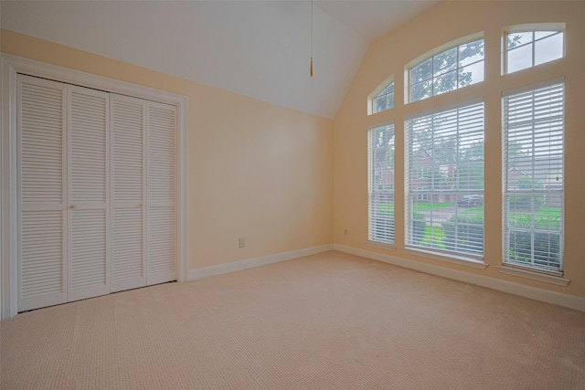 unfurnished bedroom with carpet floors, vaulted ceiling, baseboards, and a closet