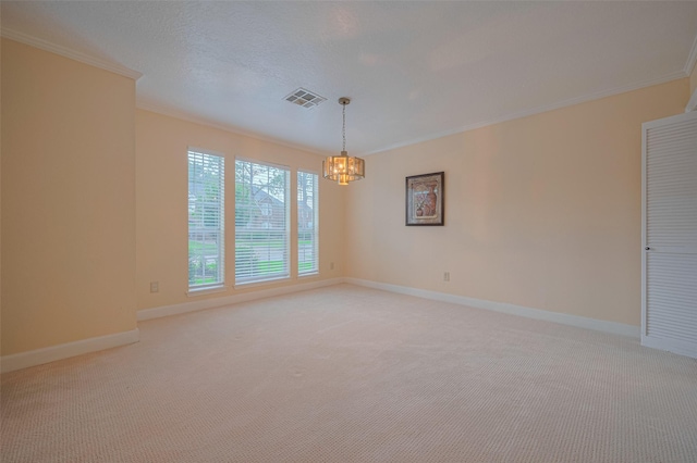 spare room featuring a chandelier, crown molding, light colored carpet, and baseboards