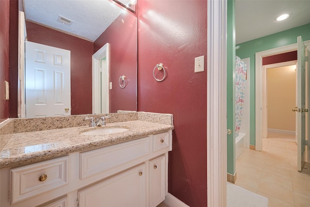 full bath featuring tile patterned flooring, vanity, shower / tub combo with curtain, and baseboards