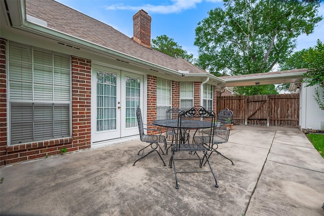 view of patio with french doors, fence, a gate, and outdoor dining space