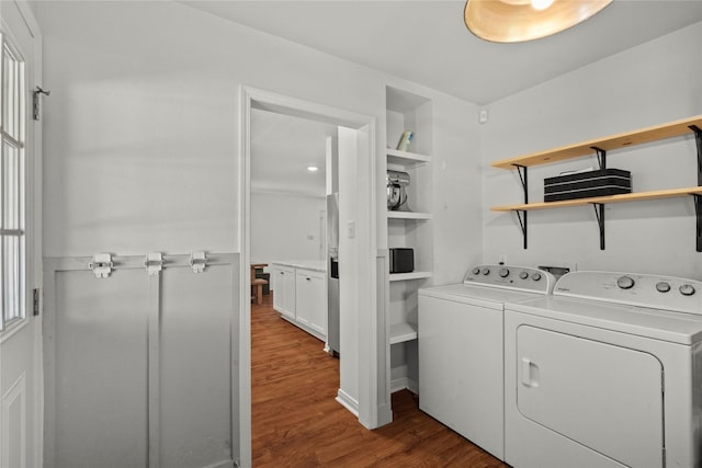laundry area with washing machine and clothes dryer and wood finished floors