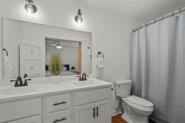 bathroom featuring toilet, double vanity, ceiling fan, and curtained shower
