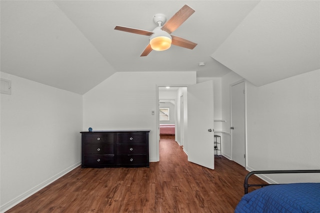 unfurnished bedroom featuring dark wood-style floors, lofted ceiling, a ceiling fan, and baseboards
