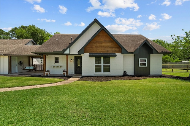 view of front of property featuring board and batten siding, roof with shingles, and brick siding