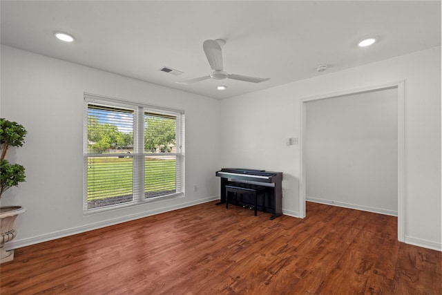empty room featuring wood finished floors, a ceiling fan, baseboards, a smoke detector, and recessed lighting
