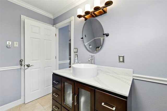 bathroom featuring vanity, ornamental molding, tile patterned floors, and baseboards