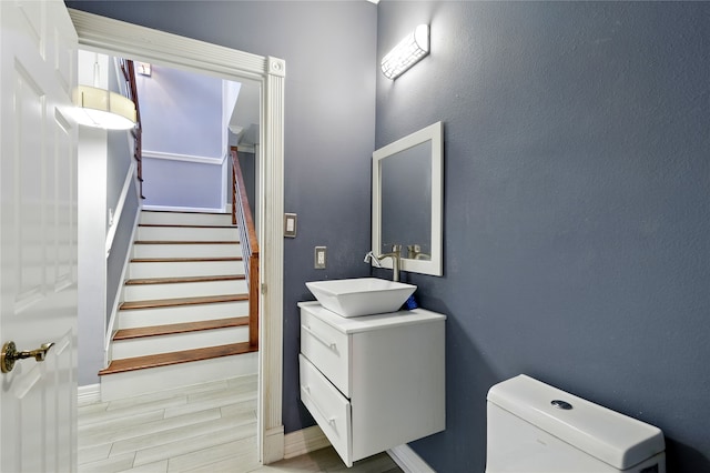 bathroom with vanity, toilet, baseboards, and wood finished floors