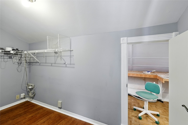laundry area featuring a desk, baseboards, and wood finished floors