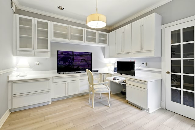 office with built in study area, light wood finished floors, and crown molding