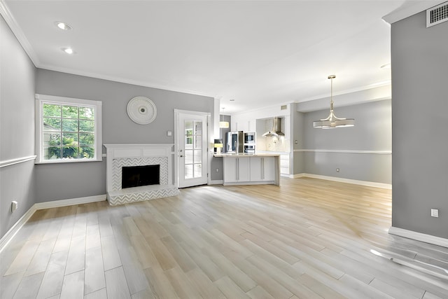 unfurnished living room featuring ornamental molding, baseboards, a fireplace, light wood-style flooring, and recessed lighting
