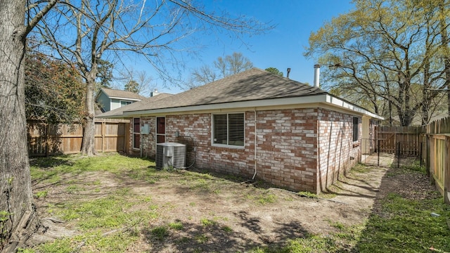 31311 N Head Dr, Spring, TX 77386 - rear view of property featuring central air condition unit, a shingled roof, a fenced backyard, and brick siding