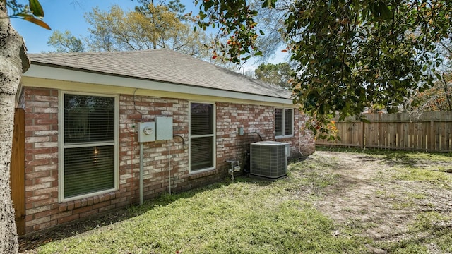 31311 N Head Dr, Spring, TX 77386 - rear view of house with central AC unit, a shingled roof, and brick siding