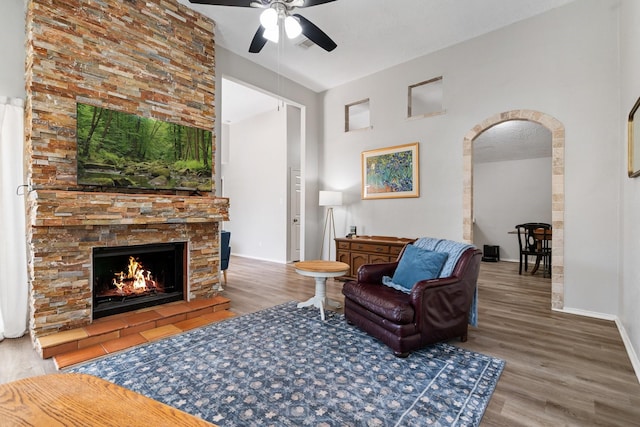 31311 N Head Dr, Spring, TX 77386 - living area with a ceiling fan, wood finished floors, arched walkways, and a stone fireplace