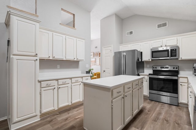 31311 N Head Dr, Spring, TX 77386 - kitchen featuring appliances with stainless steel finishes, wood finished floors, high vaulted ceiling, and light countertops