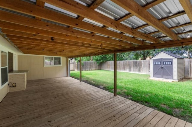 wooden deck with a storage shed and an outdoor structure