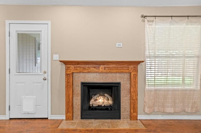 detailed view of wood finished floors, baseboards, and a fireplace