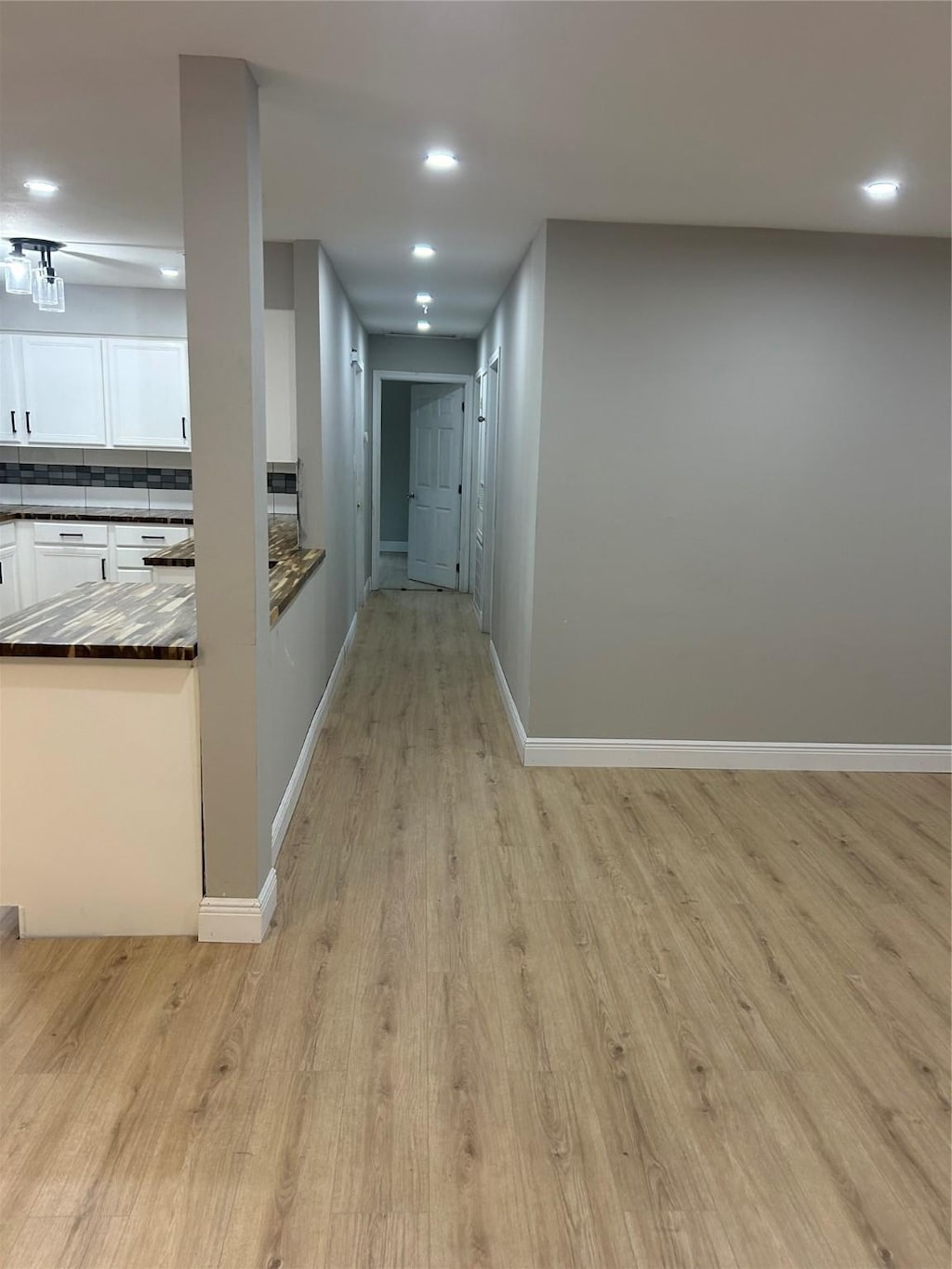 hallway with recessed lighting, light wood-type flooring, and baseboards