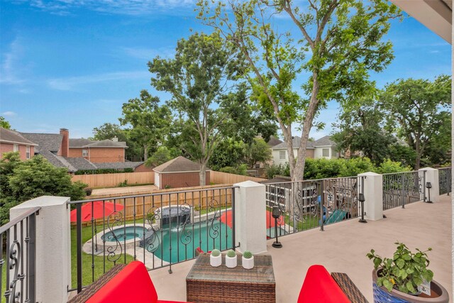 view of patio with a fenced backyard and a pool with connected hot tub