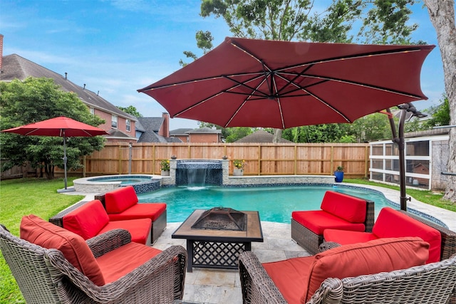 view of pool with an outdoor living space with a fire pit, a pool with connected hot tub, and a patio area