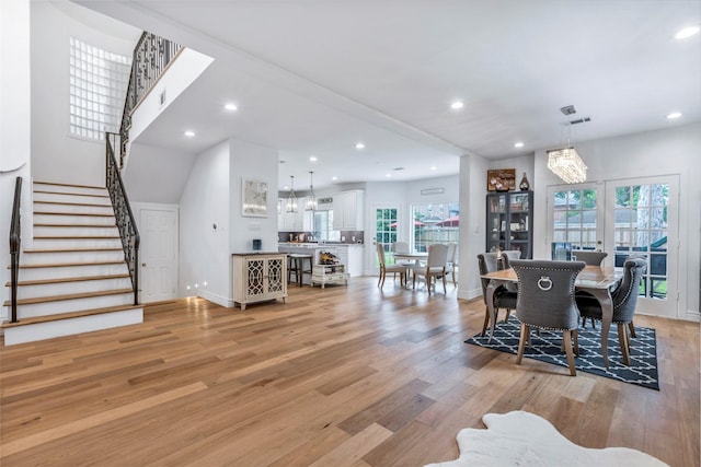 dining space featuring light wood-style floors, stairs, baseboards, plenty of natural light, and recessed lighting