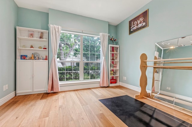 workout area featuring wood finished floors and baseboards