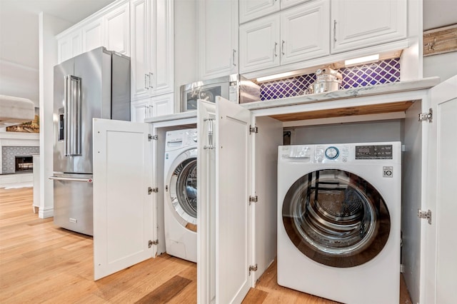 laundry room featuring washer / dryer and light wood-style flooring