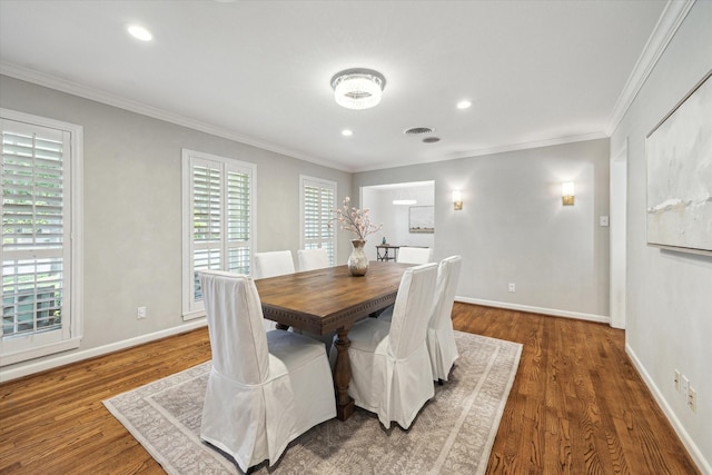 dining room with wood finished floors, crown molding, baseboards, and recessed lighting