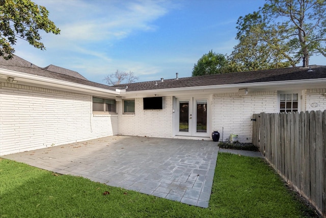 back of house with brick siding, french doors, and a patio