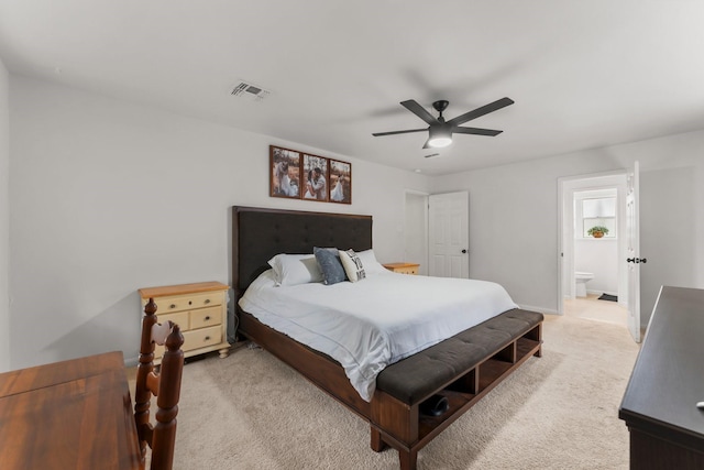 bedroom with light colored carpet, ceiling fan, connected bathroom, and baseboards