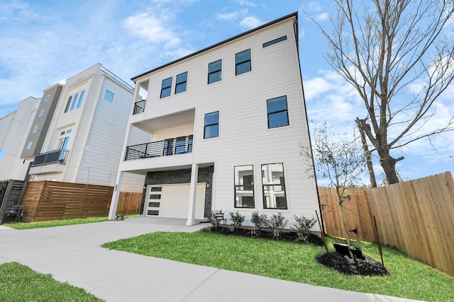 view of front of home with a balcony, concrete driveway, and an attached garage