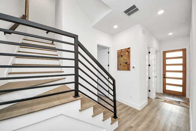 entryway with stairs, light wood finished floors, baseboards, and recessed lighting