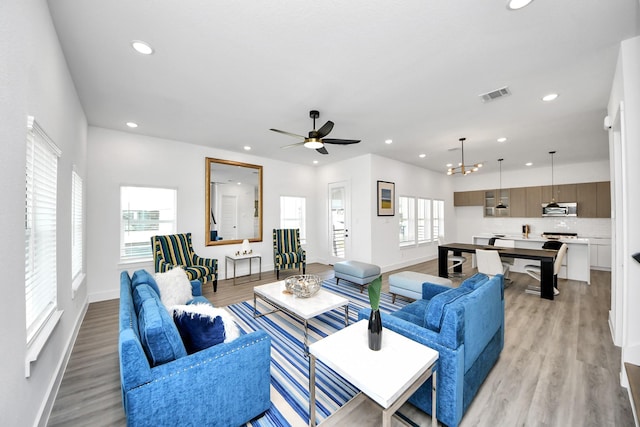 living area with recessed lighting, healthy amount of natural light, light wood finished floors, and ceiling fan