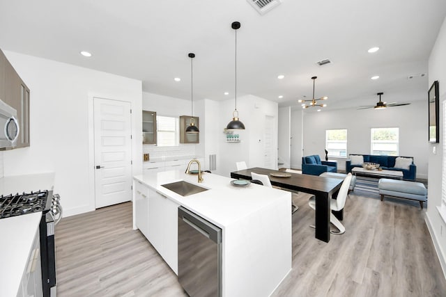 kitchen featuring a sink, appliances with stainless steel finishes, recessed lighting, light wood-style flooring, and a ceiling fan