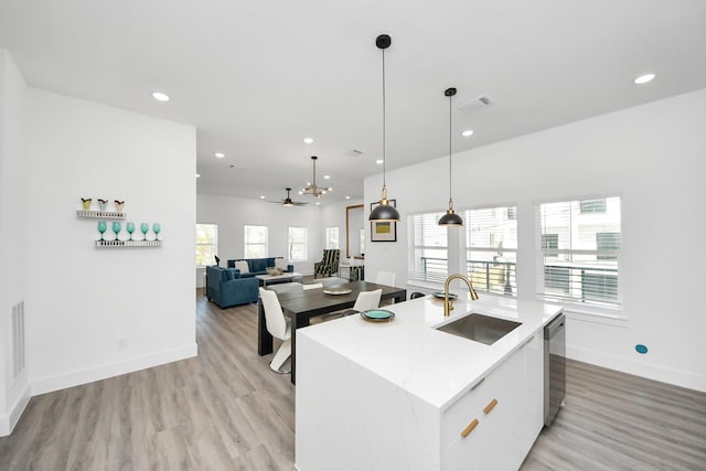 kitchen with a sink, a ceiling fan, light wood-style flooring, a center island with sink, and recessed lighting