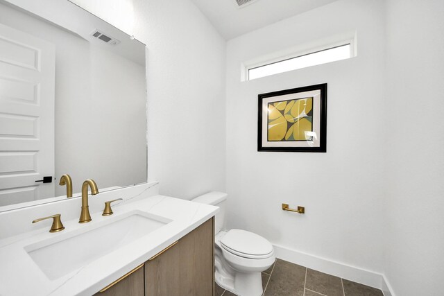 bathroom featuring toilet, tile patterned floors, vanity, and baseboards