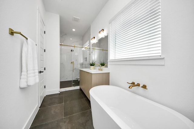 full bathroom with vanity, a marble finish shower, a freestanding bath, and tile patterned floors