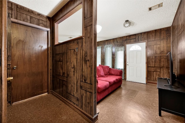 7434 Langley Rd, Houston, TX 77016 - foyer entrance with wood walls, tile patterned floors, and a textured ceiling