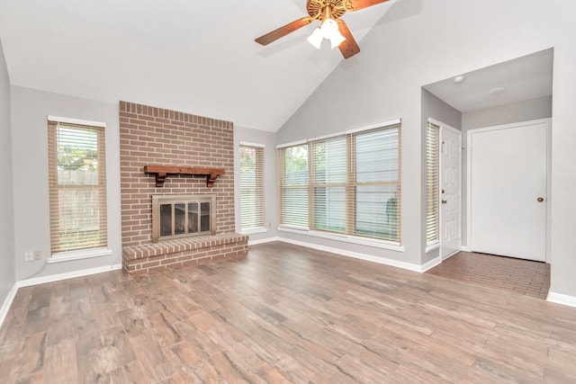 2815 Panagard Dr Unit 38, Houston, TX 77082 - unfurnished living room with wood finished floors, baseboards, ceiling fan, high vaulted ceiling, and a brick fireplace