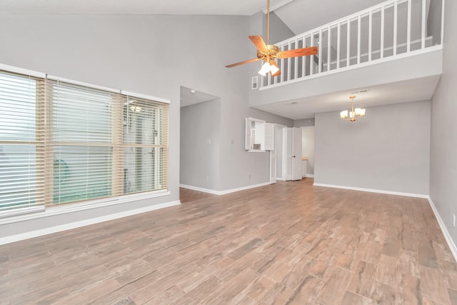 2815 Panagard Dr Unit 38, Houston, TX 77082 - unfurnished living room with a chandelier, baseboards, wood finished floors, a ceiling fan, and high vaulted ceiling
