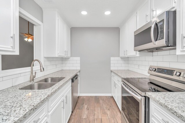 2815 Panagard Dr Unit 38, Houston, TX 77082 - kitchen featuring stainless steel appliances, a sink, white cabinets, tasteful backsplash, and recessed lighting