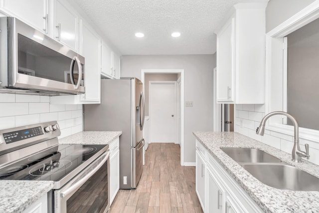 2815 Panagard Dr Unit 38, Houston, TX 77082 - kitchen with appliances with stainless steel finishes, a sink, white cabinetry, recessed lighting, and a textured ceiling