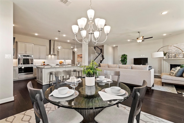 dining area featuring dark wood finished floors, a chandelier, ceiling fan, recessed lighting, and baseboards